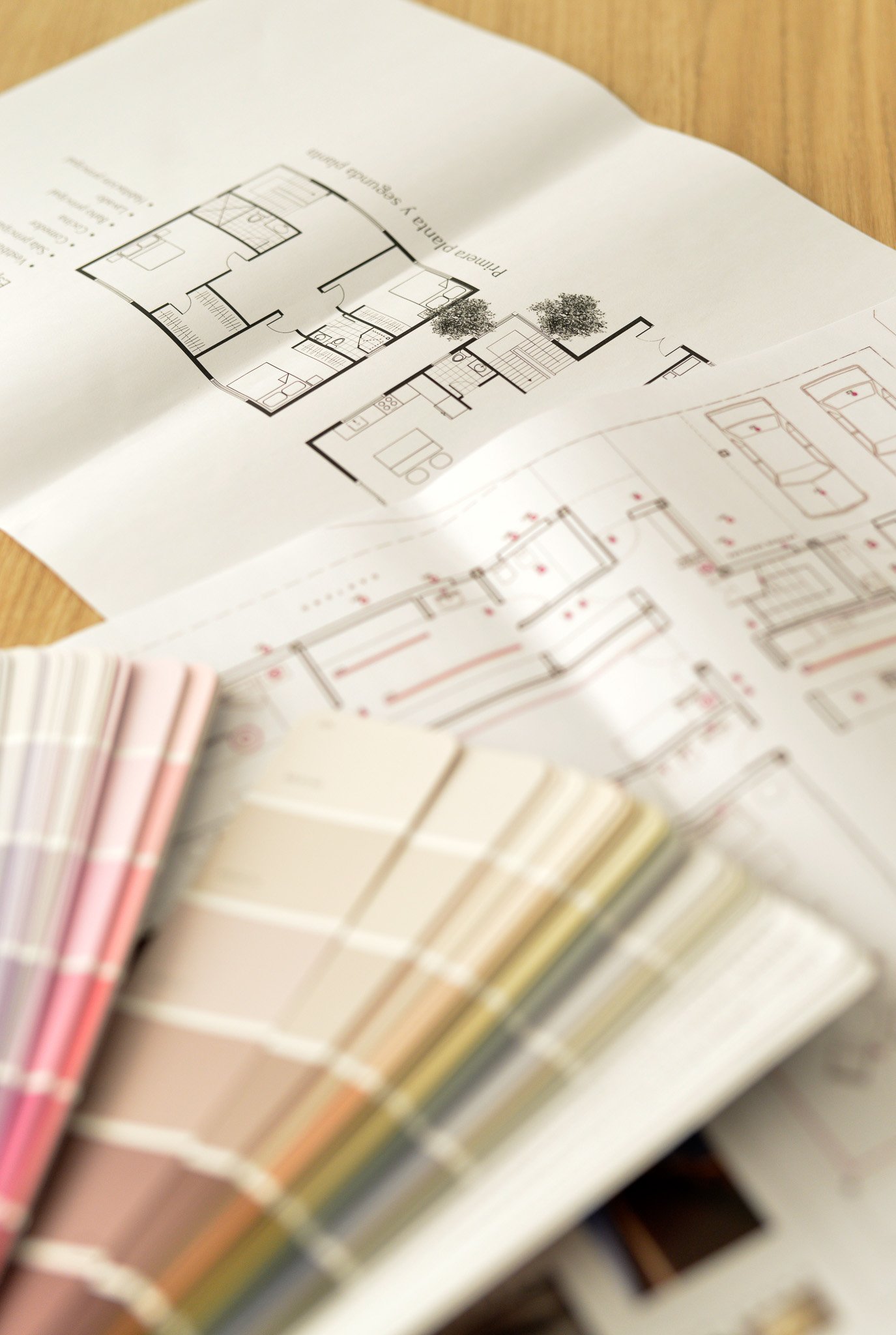 Planos de vivienda y muestrario de colores sobre una mesa de diseño.