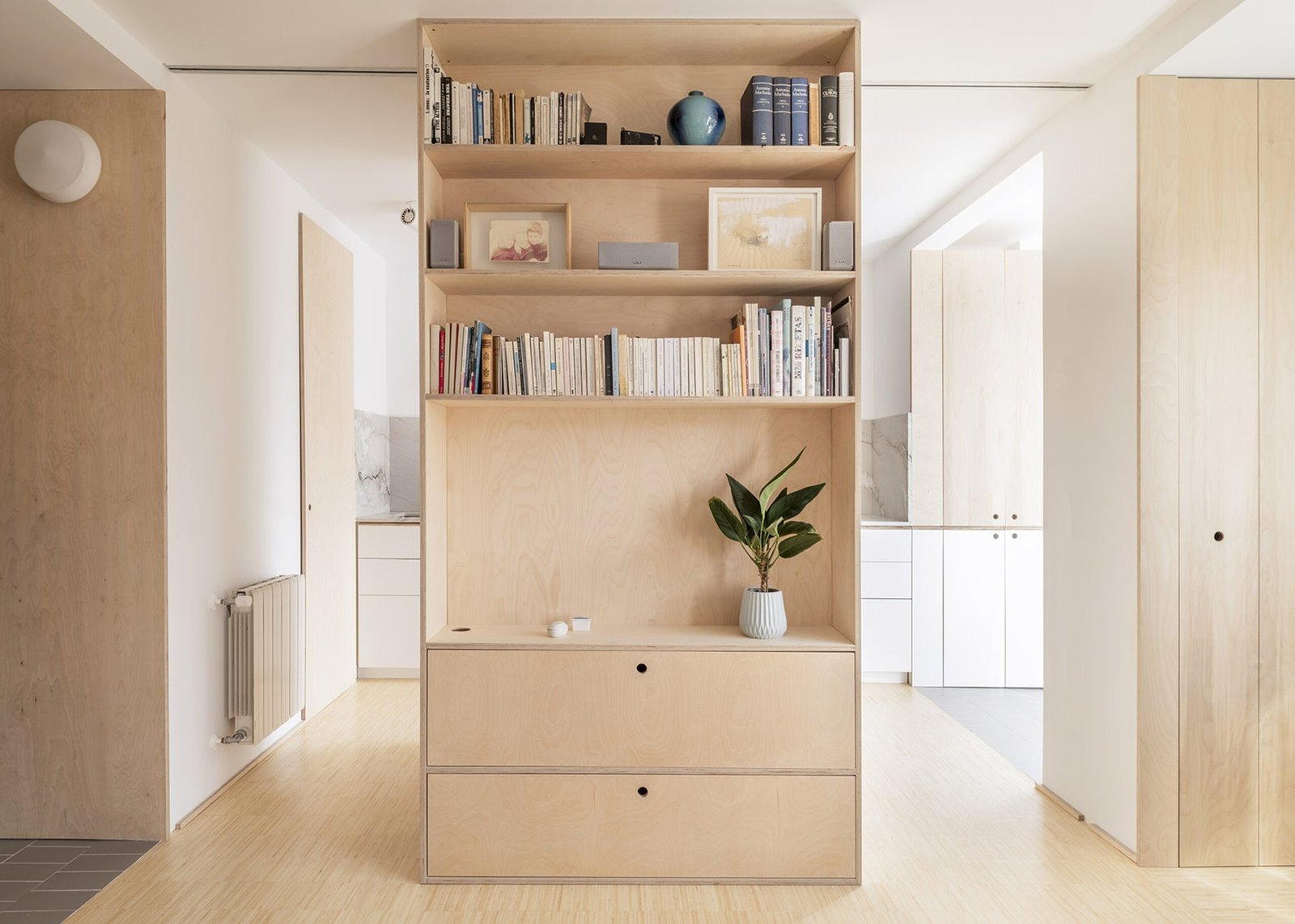 Interior minimalista amb prestatgeria encastada de fusta clara que transmet ordre, equilibri i benestar.