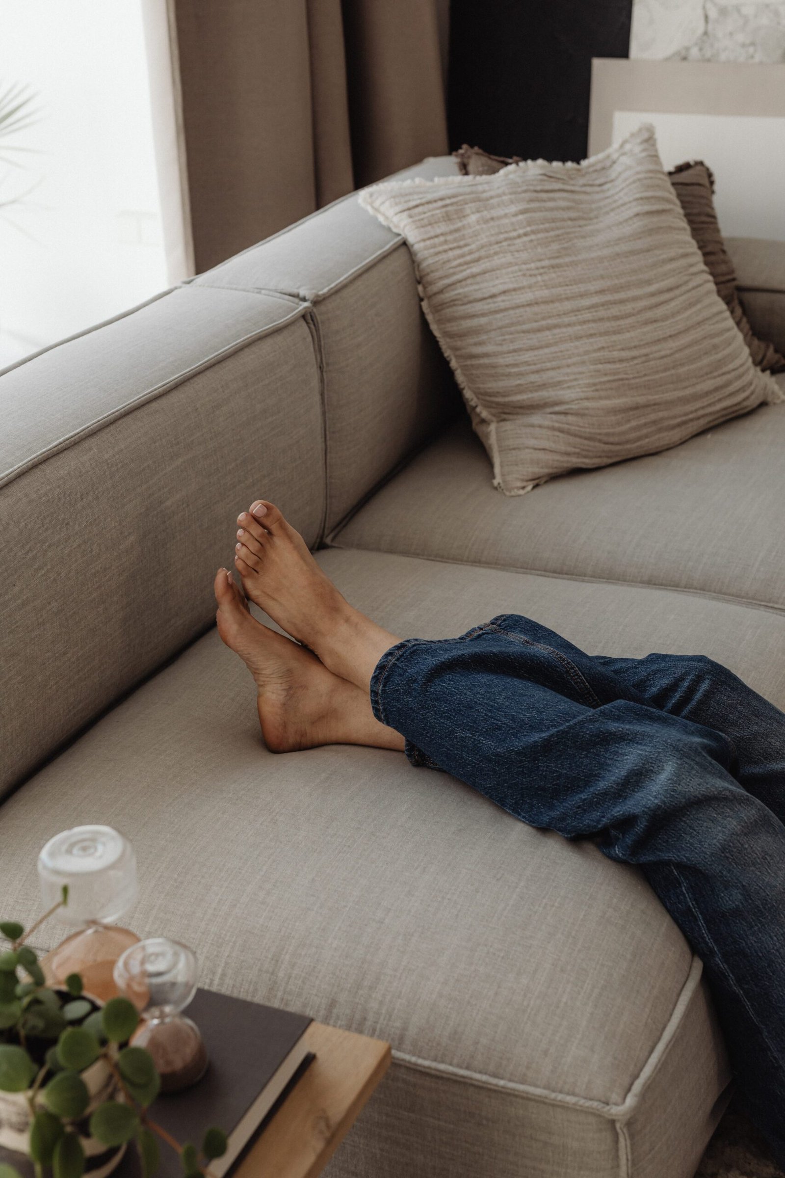 Persona descansant en un sofà clar que transmet calma i sensació de refugi